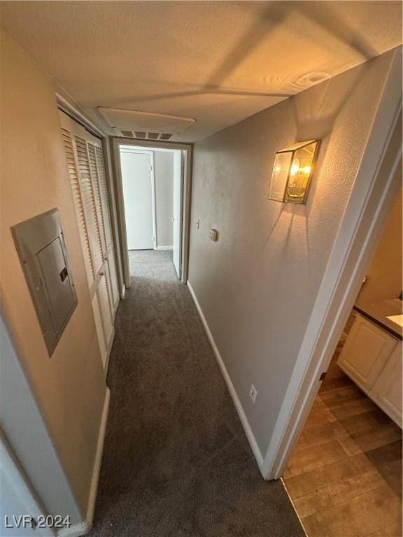 hallway with light carpet and electric panel