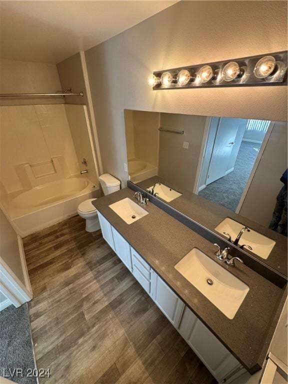 full bathroom featuring hardwood / wood-style floors, vanity, toilet, and shower / tub combination