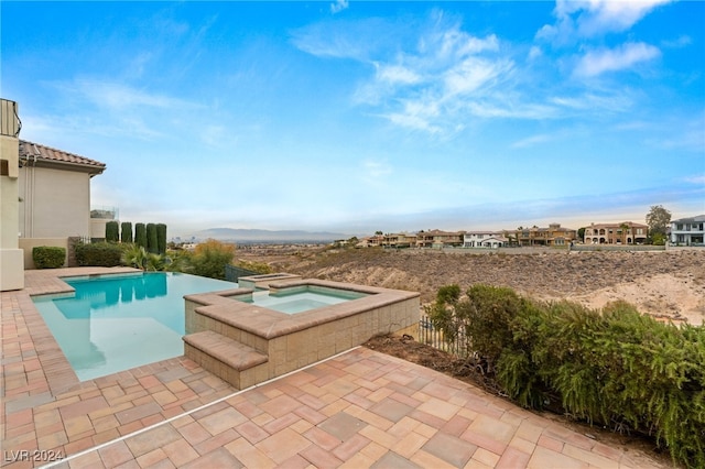 view of pool with a patio area and an in ground hot tub