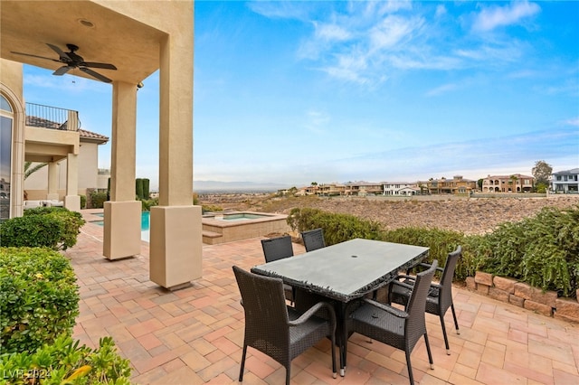 view of patio / terrace featuring an in ground hot tub, a balcony, and ceiling fan