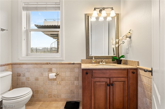 bathroom with tile patterned floors, vanity, toilet, and tile walls