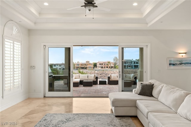 living room featuring plenty of natural light, ornamental molding, and ceiling fan