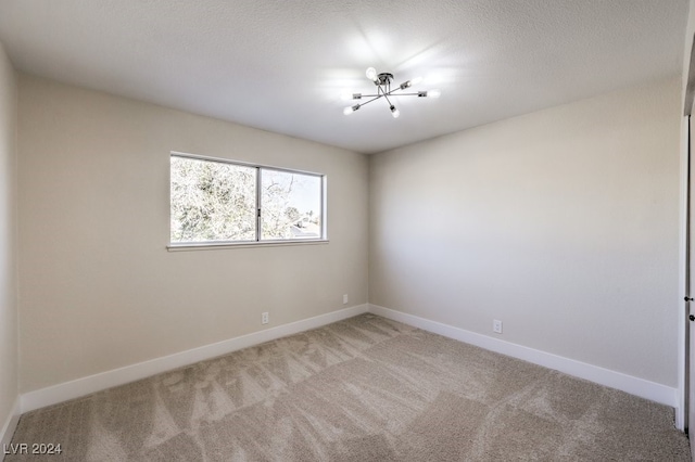 unfurnished room with carpet floors and a textured ceiling