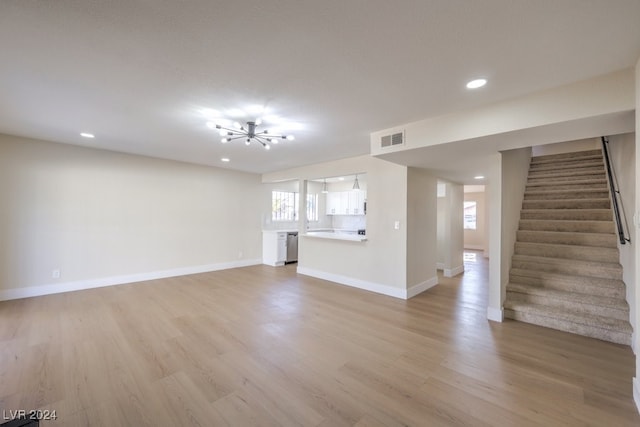 unfurnished living room with a chandelier and light hardwood / wood-style floors