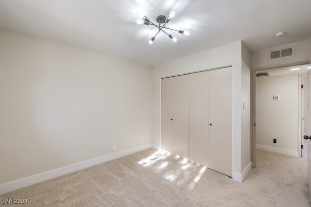 unfurnished bedroom with light carpet and a closet