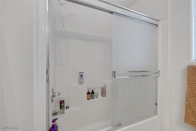 bathroom featuring bath / shower combo with glass door