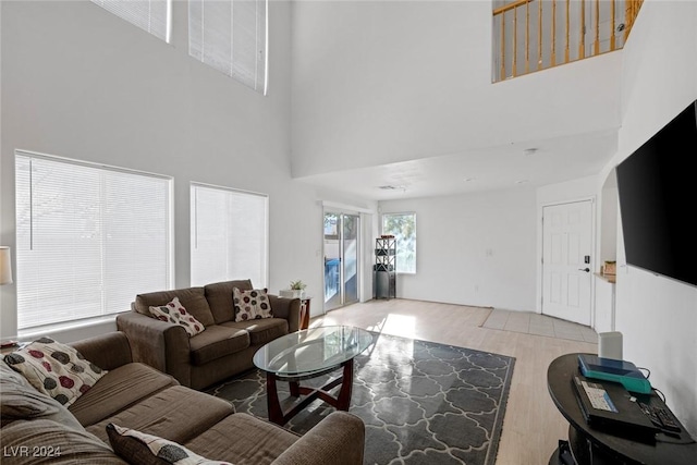 living room with a towering ceiling and light hardwood / wood-style floors