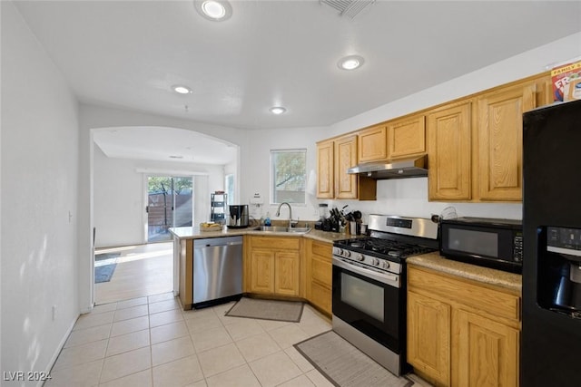 kitchen featuring kitchen peninsula, light tile patterned floors, sink, and black appliances