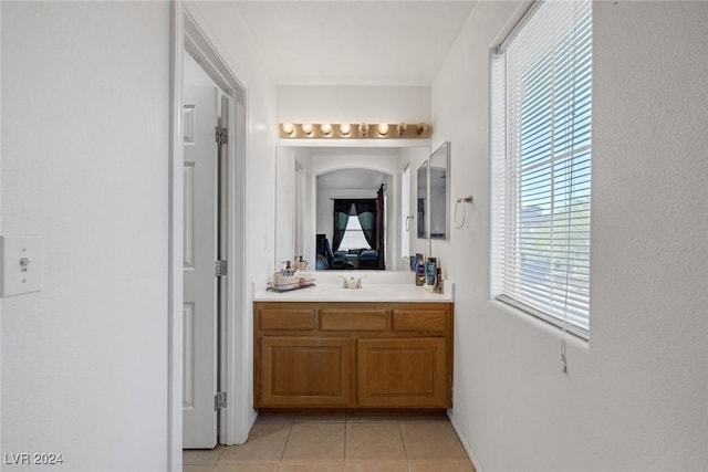 bathroom with tile patterned floors, vanity, and a wealth of natural light