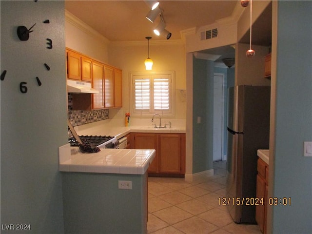 kitchen with sink, ornamental molding, decorative light fixtures, kitchen peninsula, and stainless steel appliances