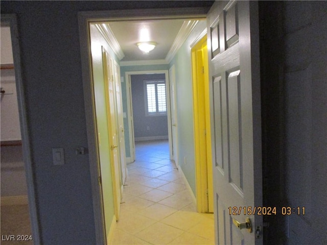 hallway featuring ornamental molding and light tile patterned flooring