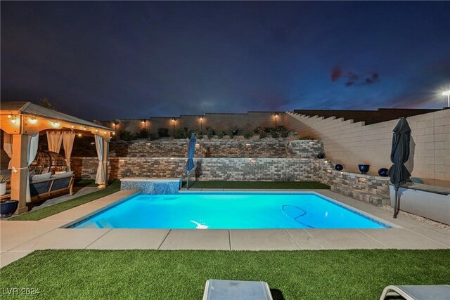 pool at twilight featuring outdoor lounge area and a patio area