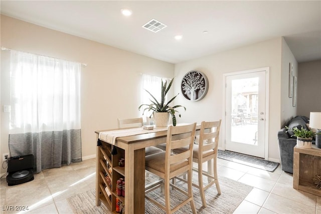 dining space with a wealth of natural light and light tile patterned flooring