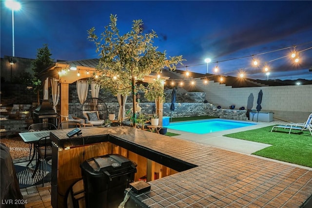 pool at twilight featuring a patio