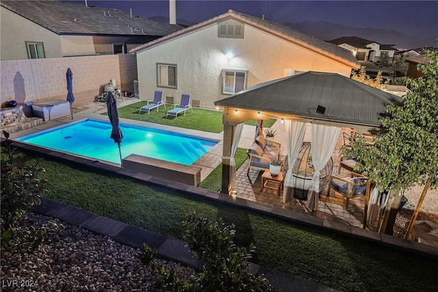 pool at dusk with a yard and a patio