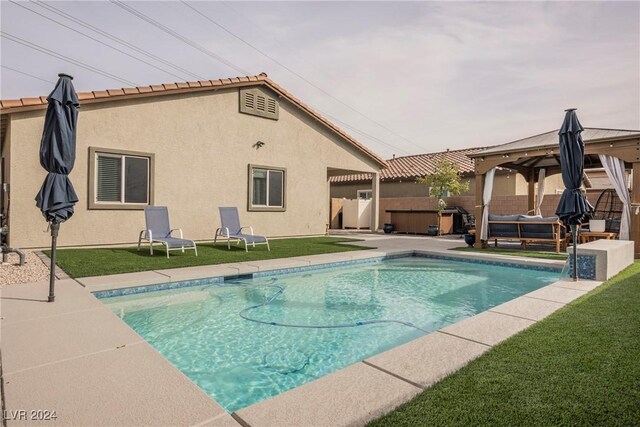 view of pool with a patio area, a yard, and a hot tub