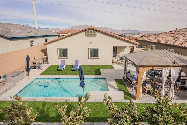 back of house with a gazebo, a patio area, a yard, and a fenced in pool