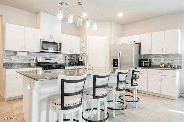 kitchen featuring white cabinetry, a center island with sink, stainless steel appliances, and sink