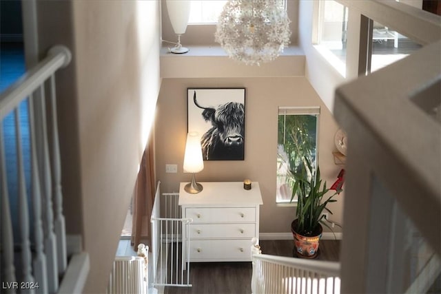 interior space featuring wood-type flooring, a towering ceiling, and an inviting chandelier