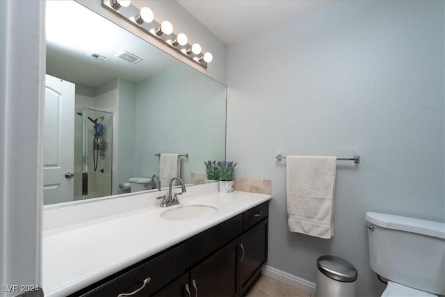 bathroom featuring vanity, a shower with door, and toilet