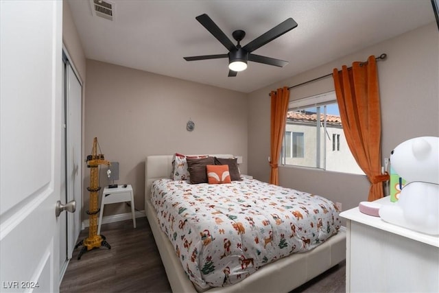 bedroom with ceiling fan, dark hardwood / wood-style flooring, and a closet