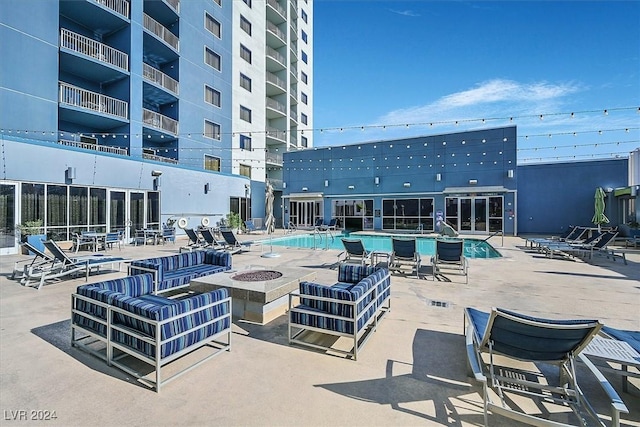 view of swimming pool featuring a patio and a fire pit