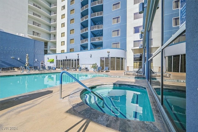 view of pool featuring a patio and a hot tub