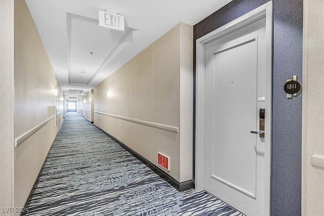 hallway featuring dark colored carpet