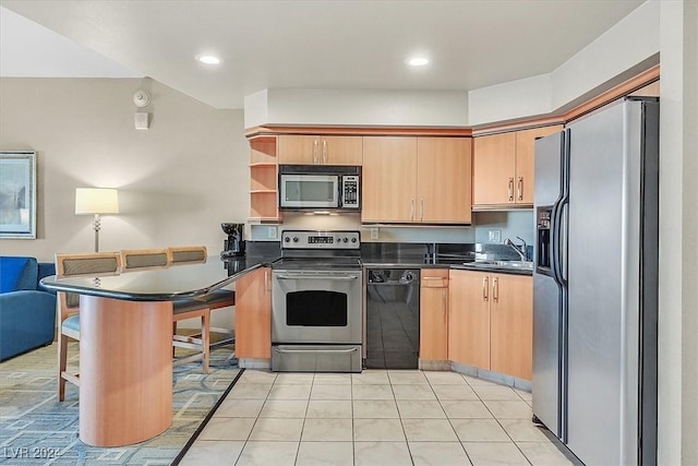 kitchen featuring sink, kitchen peninsula, a kitchen bar, light tile patterned flooring, and appliances with stainless steel finishes