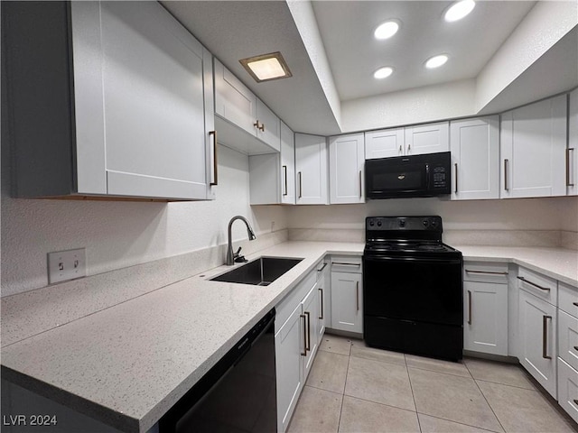 kitchen featuring black appliances, white cabinetry, sink, and light tile patterned floors