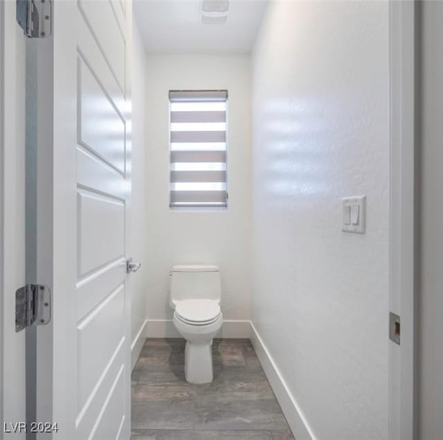 bathroom with hardwood / wood-style floors and toilet