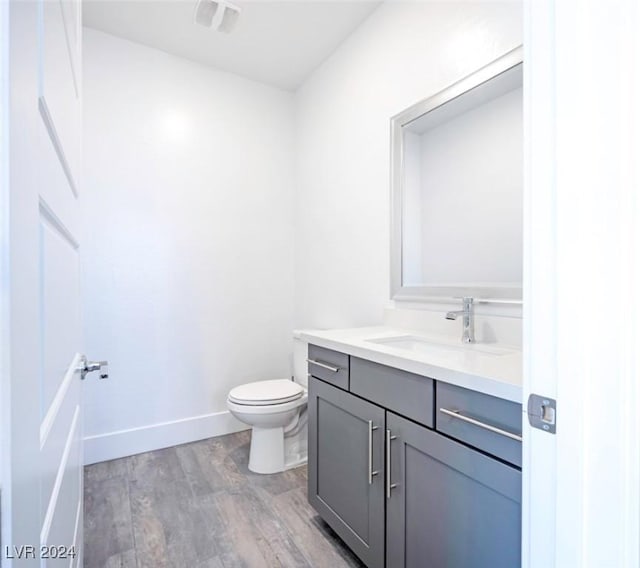 bathroom featuring hardwood / wood-style floors, vanity, and toilet