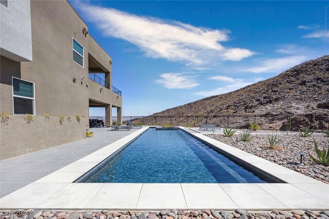 view of swimming pool with a patio area and a mountain view