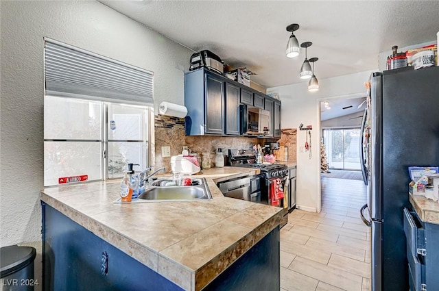 kitchen with backsplash, sink, hanging light fixtures, appliances with stainless steel finishes, and kitchen peninsula