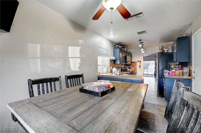 dining area with ceiling fan, wood-type flooring, and a textured ceiling