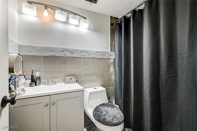 bathroom with a shower with curtain, vanity, a textured ceiling, tile walls, and toilet