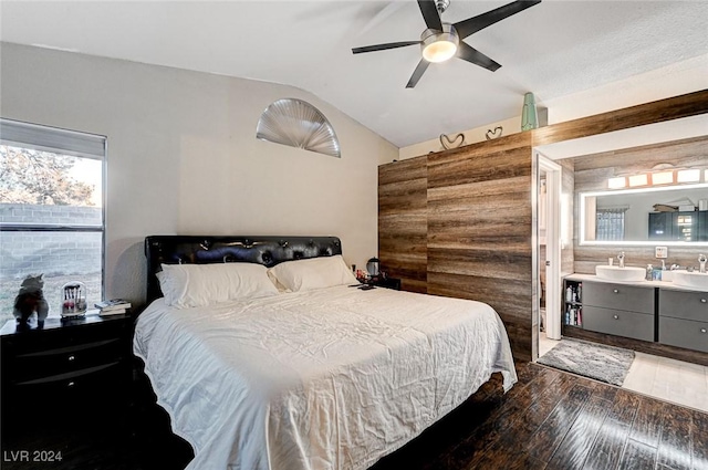 bedroom with dark hardwood / wood-style floors, vaulted ceiling, ceiling fan, and sink