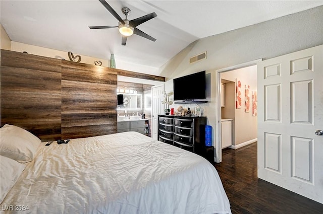 bedroom with dark hardwood / wood-style flooring, ensuite bath, ceiling fan, and lofted ceiling