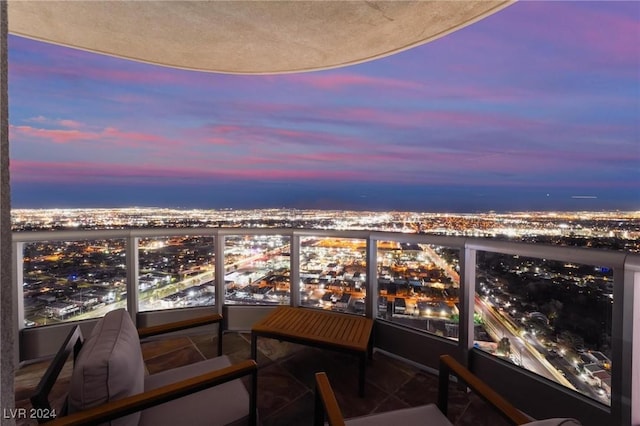 balcony at dusk featuring a city view
