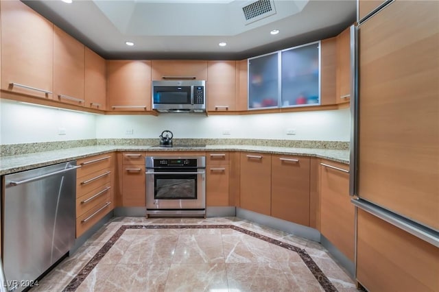 kitchen with light stone countertops and appliances with stainless steel finishes