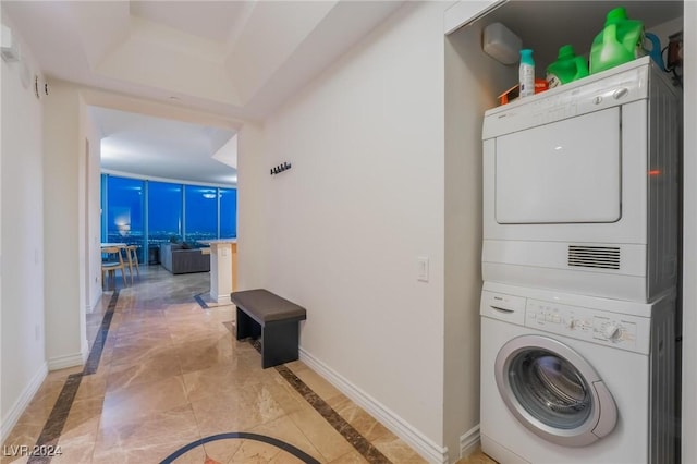 laundry room featuring tile patterned floors and stacked washer / drying machine