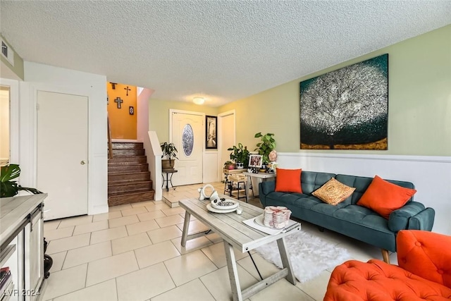 tiled living room featuring a textured ceiling