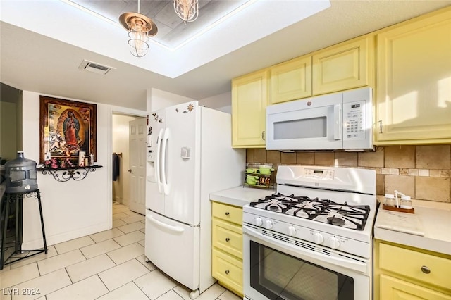 kitchen with cream cabinets, white appliances, and tasteful backsplash