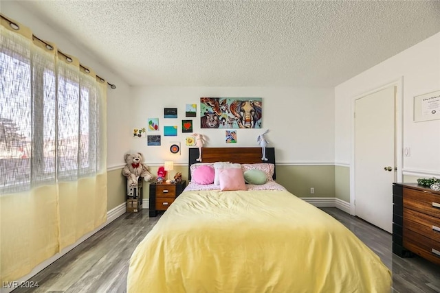 bedroom featuring dark hardwood / wood-style flooring and a textured ceiling