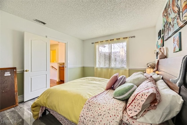 bedroom featuring a textured ceiling and hardwood / wood-style flooring