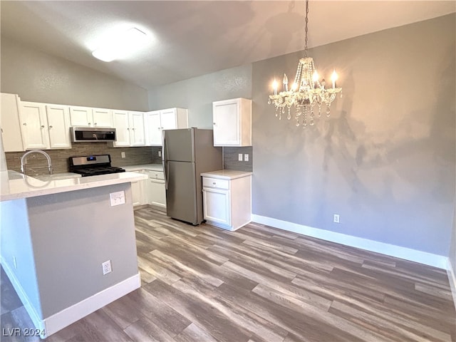 kitchen with decorative backsplash, appliances with stainless steel finishes, an inviting chandelier, light hardwood / wood-style flooring, and white cabinetry
