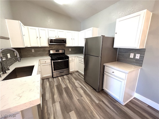 kitchen featuring decorative backsplash, appliances with stainless steel finishes, dark hardwood / wood-style flooring, sink, and white cabinets
