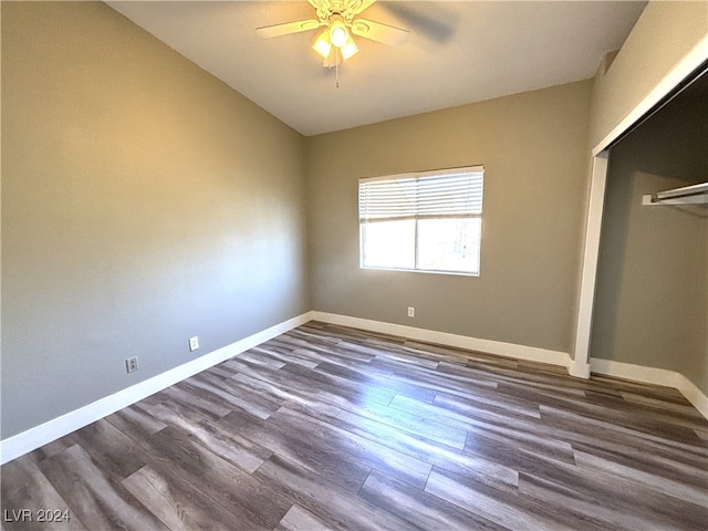 unfurnished bedroom featuring a closet, dark hardwood / wood-style floors, and ceiling fan