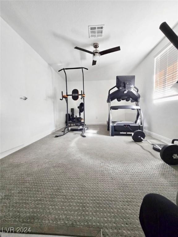 exercise room with ceiling fan and carpet