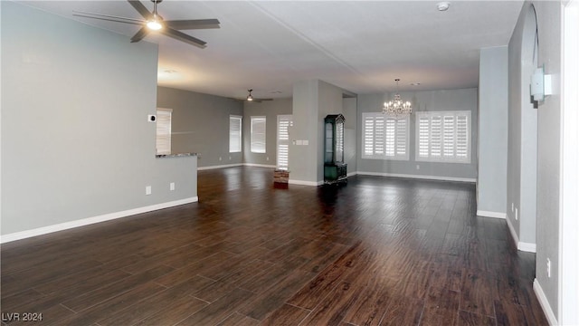 spare room featuring ceiling fan with notable chandelier and dark hardwood / wood-style floors